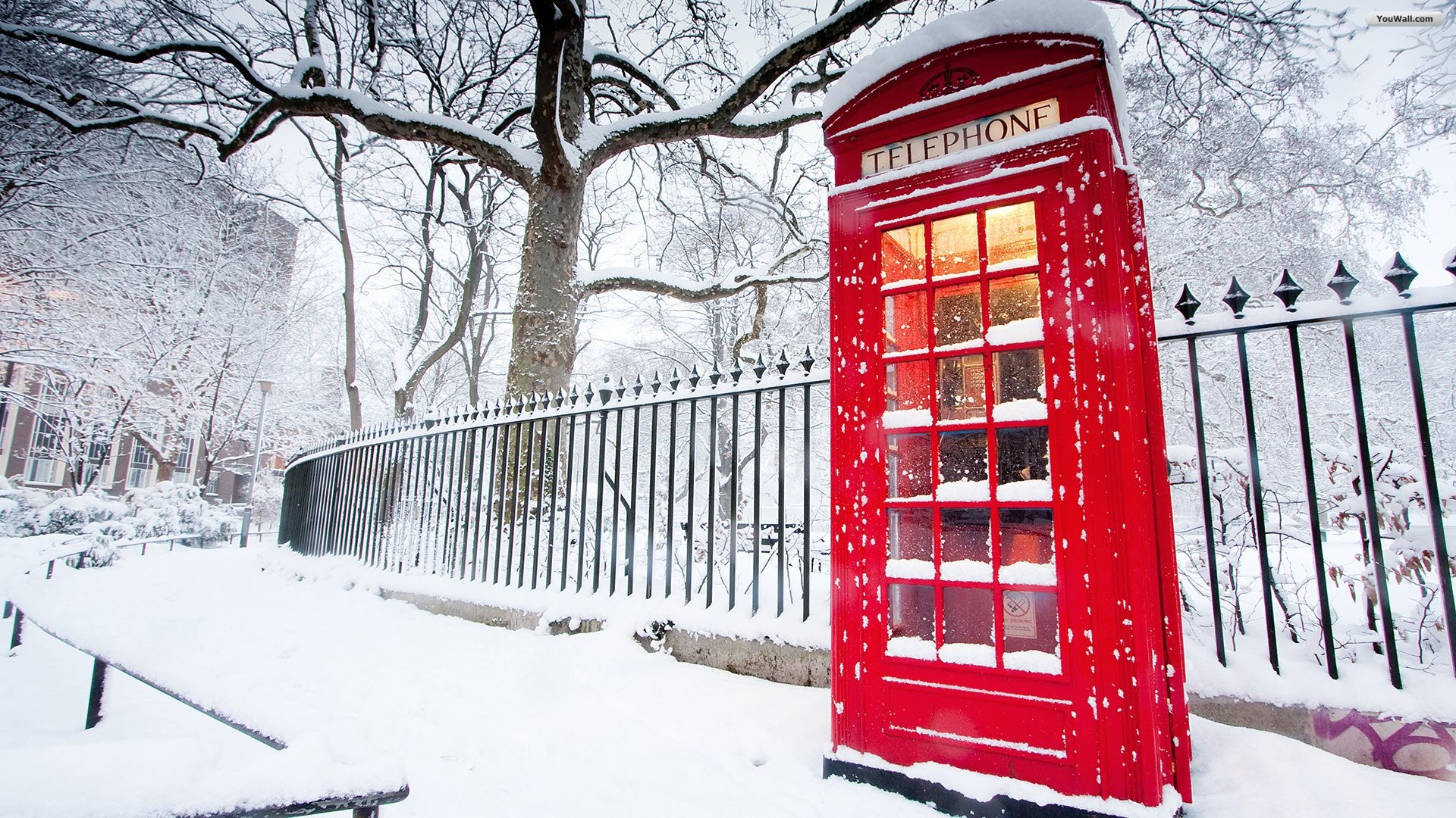 Red British phone booth in snow